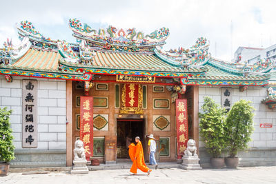 Rear view of woman outside temple against building