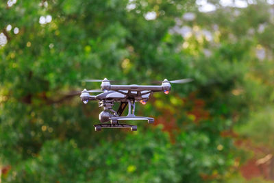 Drone flying against trees