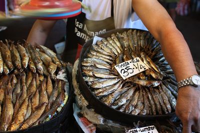 Midsection of person selling fishes at market