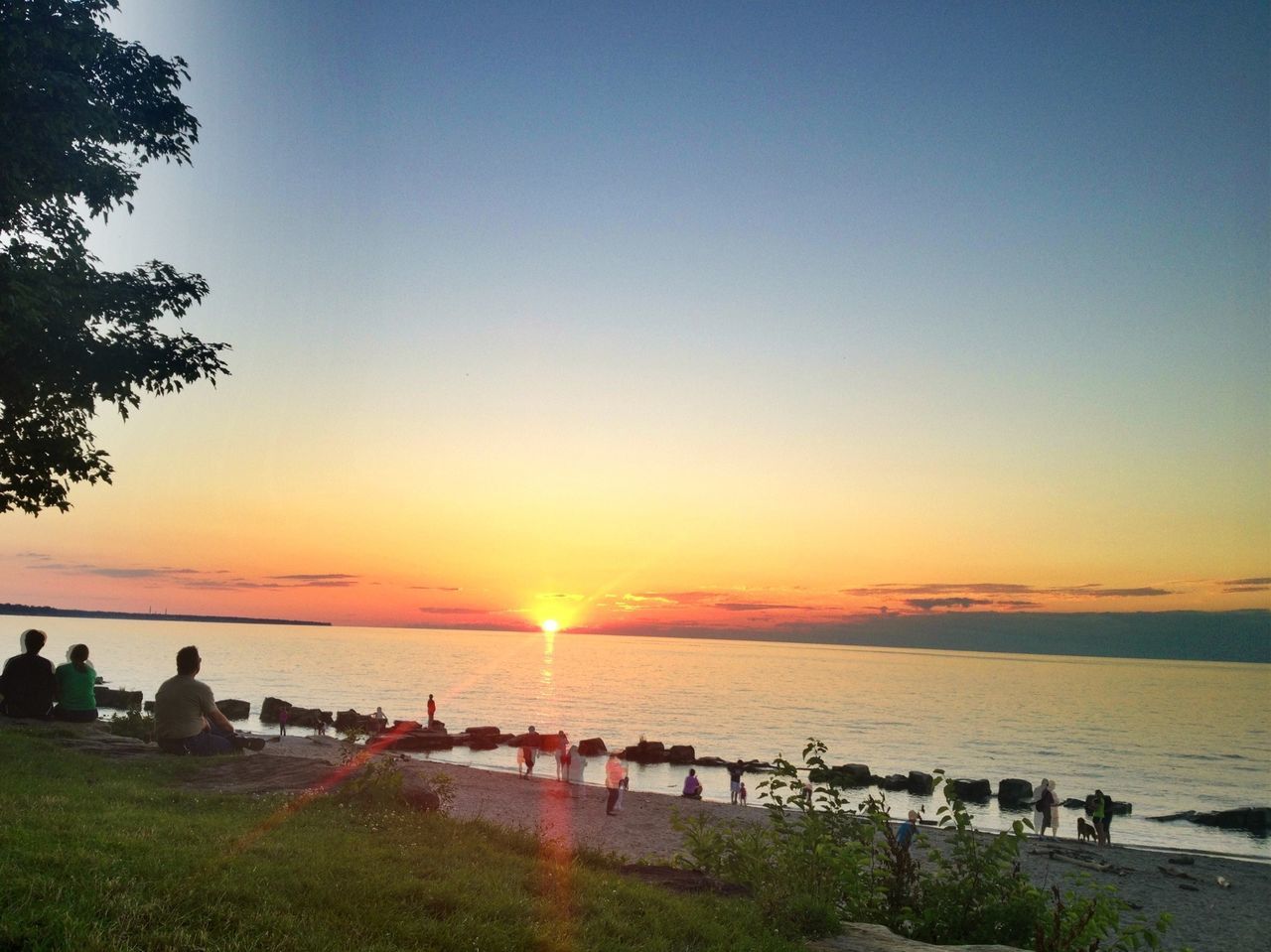 water, sunset, sea, horizon over water, scenics, large group of people, beauty in nature, tranquil scene, beach, sky, sun, tranquility, nature, leisure activity, lifestyles, shore, person, orange color, tree