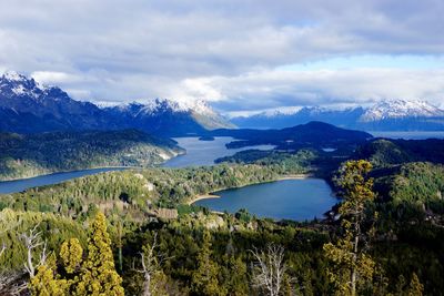 Scenic view of lake amidst forest against cloudy sky