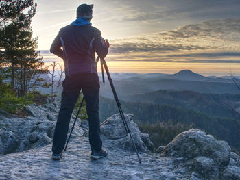 Hiker admiring the stunning misty mountain range, sunny morning. epic travel in a wilderness,