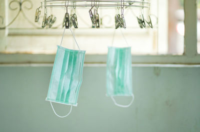 Close-up of clothes hanging on clothesline against wall