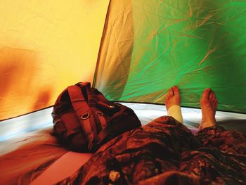 Low section of man lying on bed