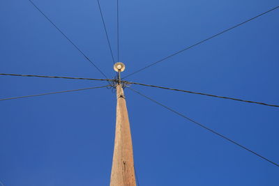 Low angle view of power lines against clear blue sky