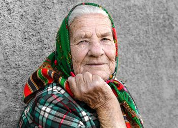 Stylish kind grandmother on a gray blurred background