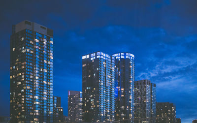 Low angle view of illuminated buildings against sky at night