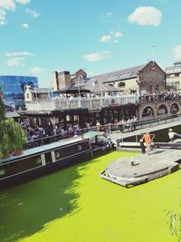 People in park by buildings against sky in city