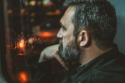 Mature man sitting at the window a public bus. mature sad man on the bus window.