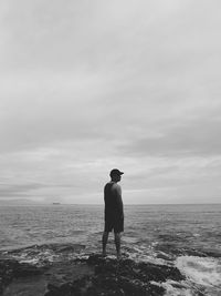 Rear view of man looking at sea against sky