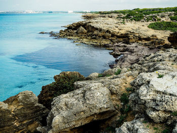 Rock formation in sea against sky