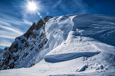 Scenic view of snowcapped mountain against cloudy sky