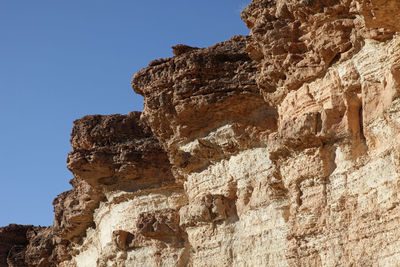 Low angle view of rock formation against clear blue sky at sahara desert