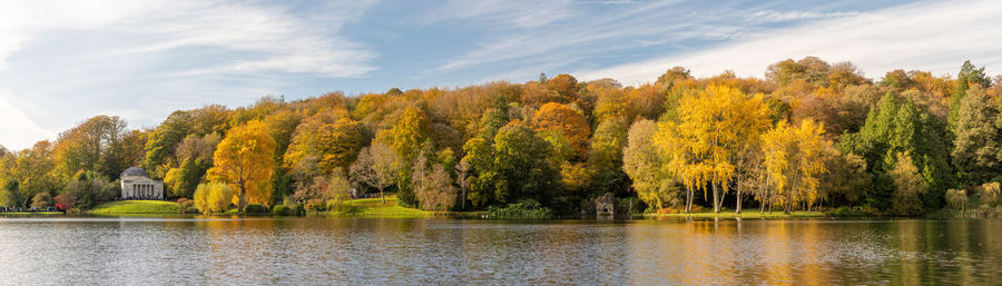 Panoramic photo of the autumn colours around the lake at stourhead gardens in wiltshire.