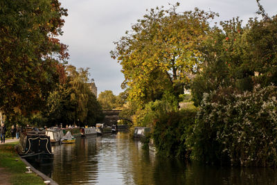 Boats moored in river against sky