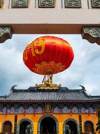 Low angle view of lantern on building against sky