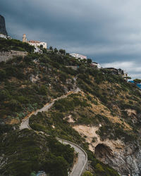 Scenic view of mountain by sea against sky