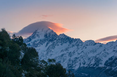 Scenic view of snowcapped mountains against sky during sunset