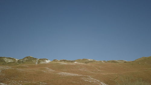 Scenic view of mountains against clear blue sky