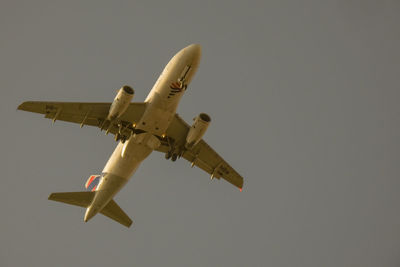 Low angle view of airplane flying against clear sky