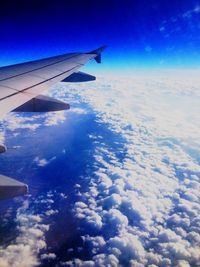 Cropped image of airplane flying over cloudscape