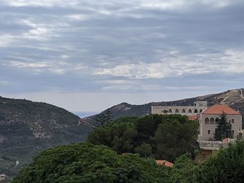 Scenic view of trees and buildings against sky