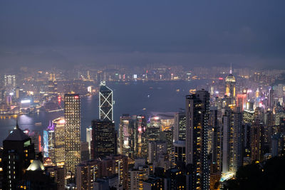 Illuminated cityscape against sky at night