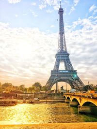 Eiffel tower against cloudy sky