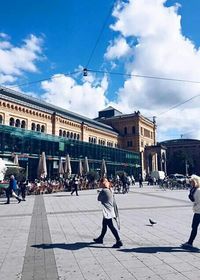 People in city against cloudy sky