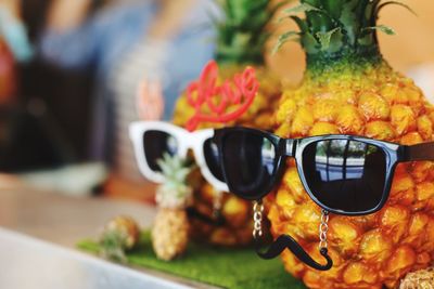 Close-up of pineapples with sunglasses on table