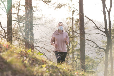 Full length of man photographing in forest