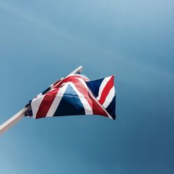 Low angle view of flag against blue sky