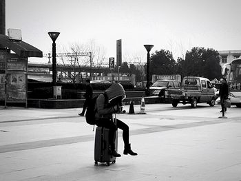 Man on road in city against sky