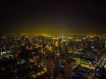 High angle view of illuminated cityscape against sky at night