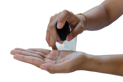 Midsection of woman holding hands against white background