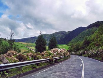 Road leading towards mountains against sky
