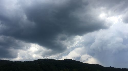 Low angle view of storm clouds over mountain