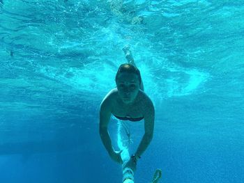 Full length of shirtless man swimming in sea