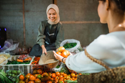 Portrait of woman holding fruits at home