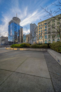 Street by buildings against sky in city