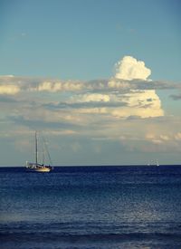 Sailboat sailing on sea against sky during sunset