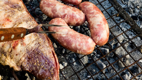 High angle view of meat on barbecue grill sausage