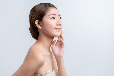 Portrait of young woman against white background