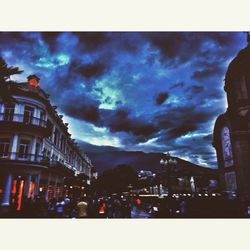 Buildings in city against cloudy sky