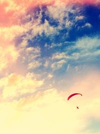 Low angle view of parachute against cloudy sky