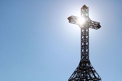 Low angle view of cross against clear blue sky