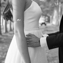 Midsection of groom holding bride on field