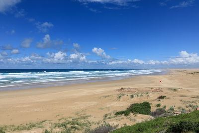 Scenic view of beach against blue sky