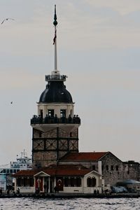 Tower amidst buildings in city at sunset