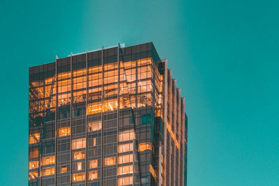 Low angle view of modern building against clear blue sky at dusk